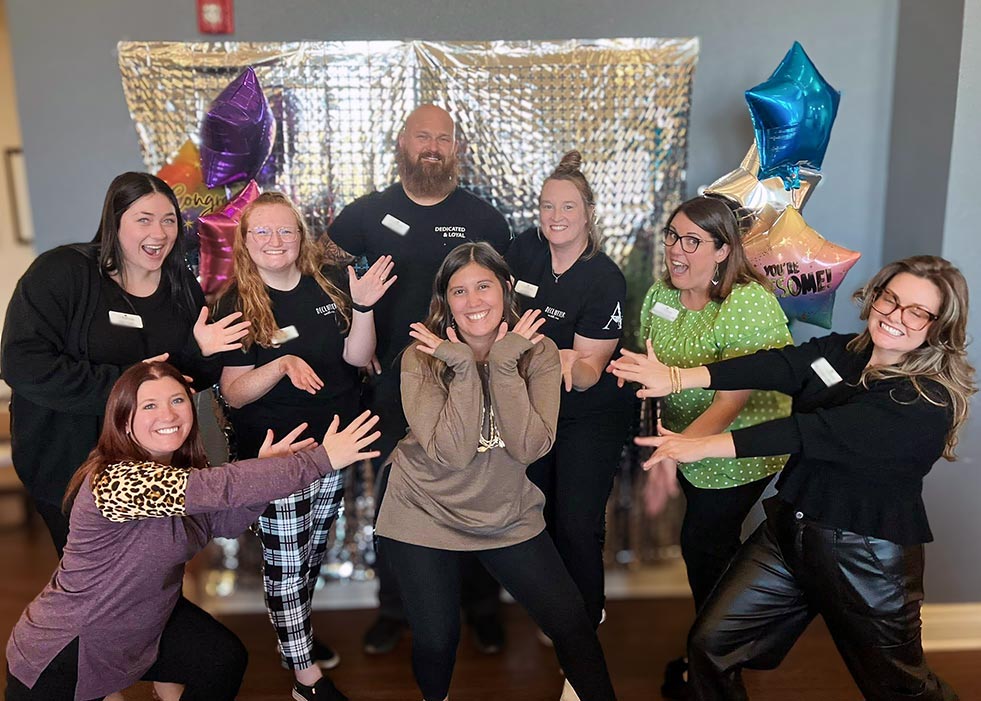 Team members pose playfully together during a gathering.