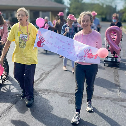 Senior residents march in a parade for Breast Cancer Awareness.