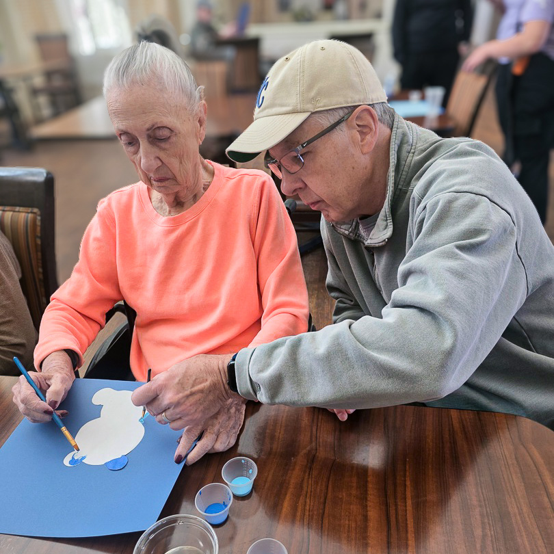 A loved one and resident engage in a relaxed art session at The Parkway Senior Living.