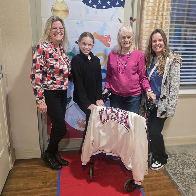 A resident smiles alongside family during an event at The Parkway Senior Living.
